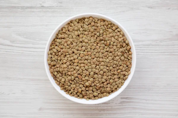 Beyaz ahşap backgrou beyaz bir kapta Organik yeşil mercimek