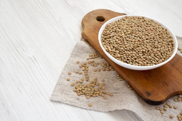 Beyaz ahşap backgrou beyaz bir kapta Organik yeşil mercimek