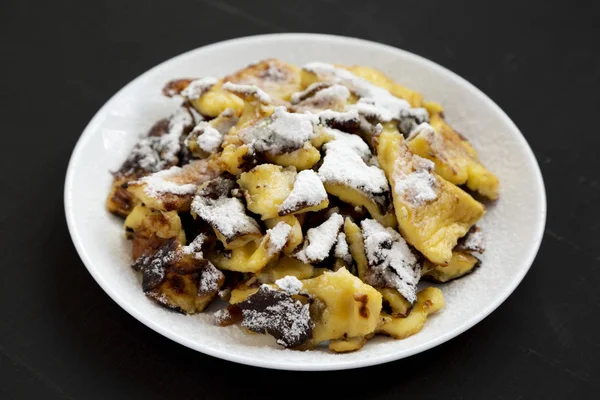 Bir bla üzerinde beyaz bir tabak üzerinde ev yapımı Alman Kaiserschmarrn gözleme