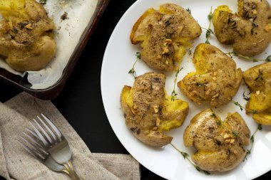 Ev yapımı sarımsak kekik bir bla üzerinde beyaz bir tabak üzerinde patates parçaladı