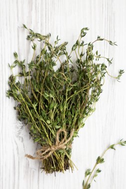 Beyaz ahşap arka plan üzerinde ham organik taze kekik, üst görünüm. 