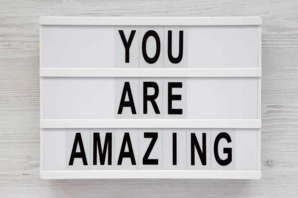 \'You are amazing\' words on a lightbox on a white wooden backgrou