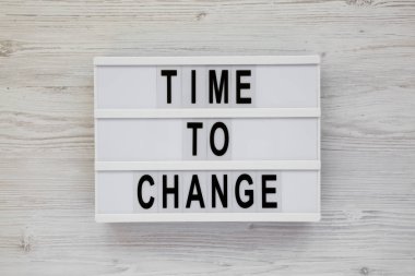 Beyaz ahşap surfa üzerinde modern bir tahta üzerinde 'zaman değiştirmek için' kelimeleri