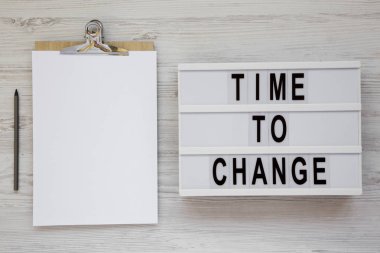 Bir ışık kutusu, boş sayfa ile pano üzerinde 'zaman değiştirmek için' kelimeleri