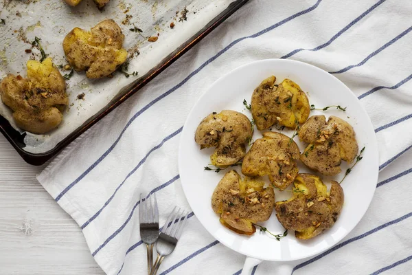 Tomillo de ajo hecho en casa aplastado patatas en un plato blanco, top vie —  Fotos de Stock