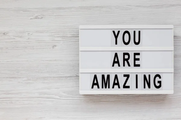 \'You are amazing\' words on a modern board on a white wooden back