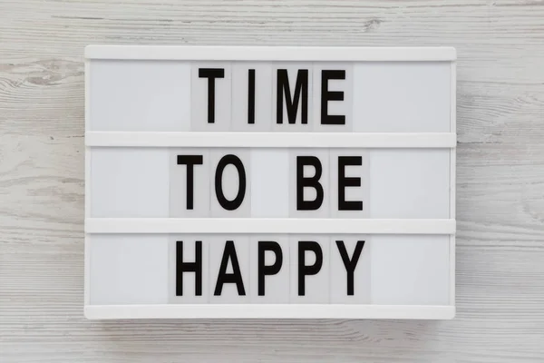 "Dags att vara lycklig" ord på en modern styrelse på en vit trä sur — Stockfoto