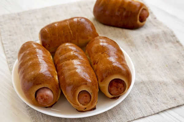 Homemade beef sausage kolache on a white plate on a white wooden — Stock Photo, Image