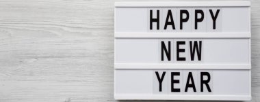 Beyaz ahşap yüzey üzerinde bir Lightbox üzerinde 'Happy new year' kelimeleri, 