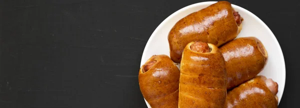 Σπιτικό βοδινό λουκάνικο kolache σε λευκό πιάτο σε μαύρο πίσω — Φωτογραφία Αρχείου