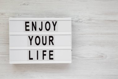 'Enjoy your life' kelimeleri beyaz ahşap sırt üzerinde modern bir tahta üzerinde
