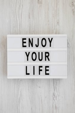 'Enjoy your life' kelimeleri beyaz ahşap sırt üzerinde modern bir tahta üzerinde