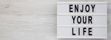 'Enjoy your life' kelimeleri beyaz ahşap sırt üzerinde modern bir tahta üzerinde