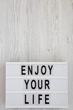 Beyaz ahşap yüzey üzerinde bir Lightbox üzerinde 'Hayatın tadını çıkarın' kelimeleri,
