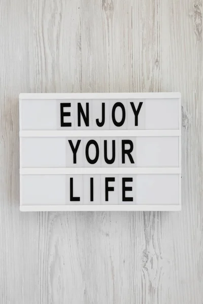 白い木製の背中の上にモダンなボード上の「あなたの人生を楽しむ」言葉 — ストック写真