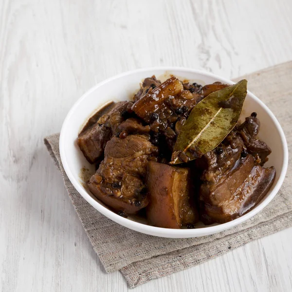 Carne di maiale filippina fatta in casa in una ciotola su un tavolo di legno bianco , — Foto Stock