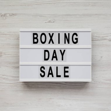 Beyaz ahşap bir yüzeyde, ışık kutusunda boks günü satışı.,