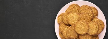 Siyah arka planda pembe bir tabakta mısır gevreği, üst manzara.. 