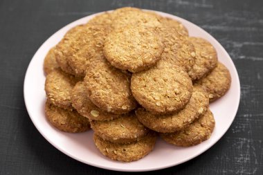 Siyah arka planda pembe bir tabakta mısır gevreği, yan görüş..