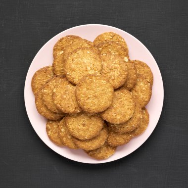 Siyah arka planda pembe bir tabakta mısır gevreği. 