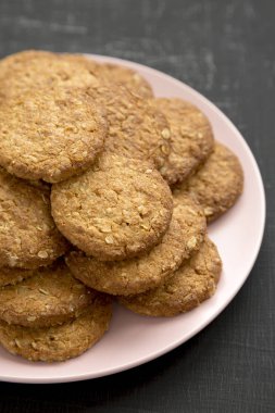 Siyah arka planda pembe bir tabakta mısır gevreği, yan görüş..