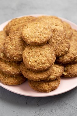 Gri bir yüzeyde pembe bir tabakta mısır gevreği, düşük açı manzaralı.