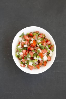 Pico de Gallo siyah arka planda beyaz bir kase içinde, başınızın üstünde.