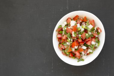 Üst manzara, Pico de Gallo siyah bir yüzey üzerinde beyaz bir kase içinde. Bitti.