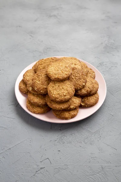 Cereal cookies on a pink plate on a gray background, low angle v