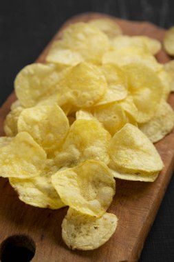 Kırsal ahşap bir tahtanın üzerinde tuzlu patates cipsi.