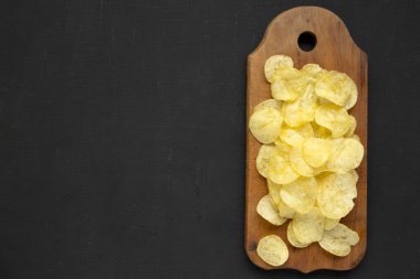 Kırsal ahşap bir tahtanın üzerinde tuzlu patates cipsi.