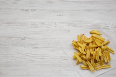 Beyaz ahşap yüzeyde tuzlu ev yapımı patates kızartması.