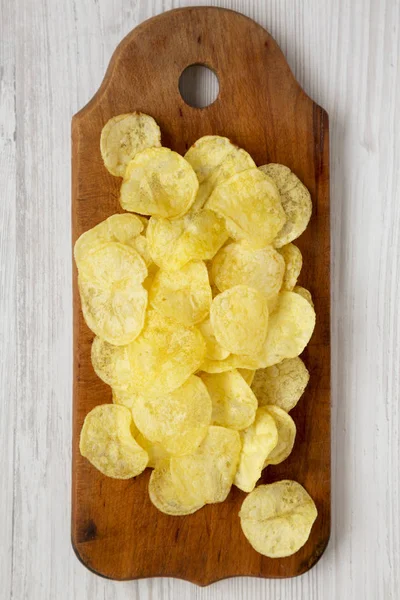白い木の板の上に塩と黄色のポテトチップス — ストック写真