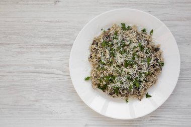 Beyaz tabakta maydanozlu ev yapımı mantarlı risotto.