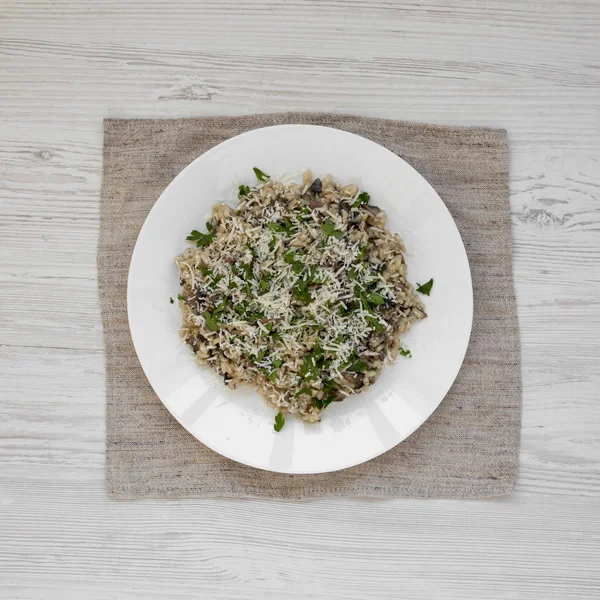 Homemade mushroom risotto with parsley on a white plate on a whi — Stock Photo, Image