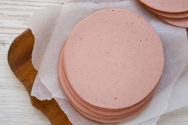 Beyaz bir tahta üzerinde dilimlenmiş domuz eti eti.