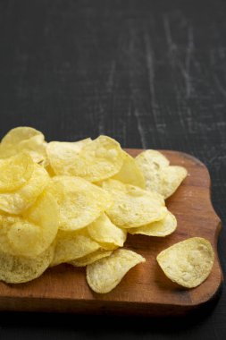 Kırsal ahşap bir tahtanın üzerinde tuzlu patates cipsi.