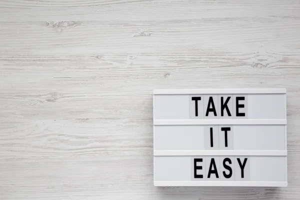 Paroles 'Take it easy' sur une planche moderne sur un backgro en bois blanc — Photo