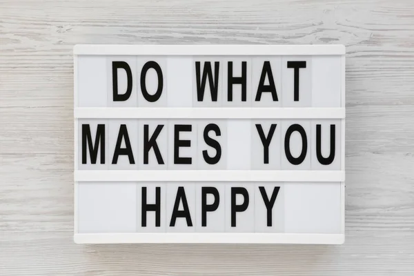 'Do what makes you happy' words on a lightbox on a white wooden — Stock Photo, Image