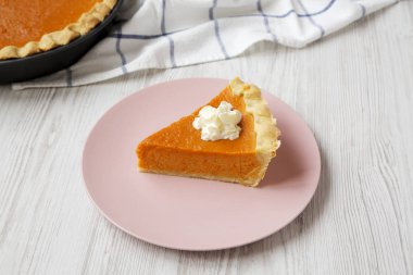 Beyaz bir kukuda pembe tabakta ev yapımı Şükran Günü kabağı turtası.