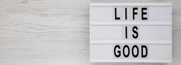 'Life is good' words on a lightbox on a white wooden surface, to — ストック写真