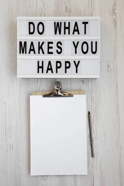 "Делай то, что делает тебя счастливым" слова в лайтбоксе, буфер обмена с bl — стоковое фото