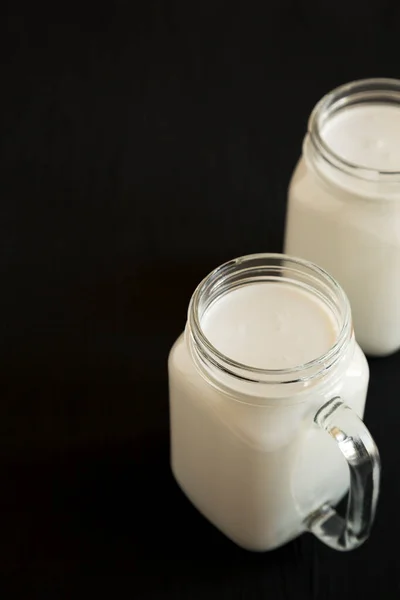 Kokosmelk Glazen Potten Een Zwarte Achtergrond Zijaanzicht Kopieerruimte — Stockfoto