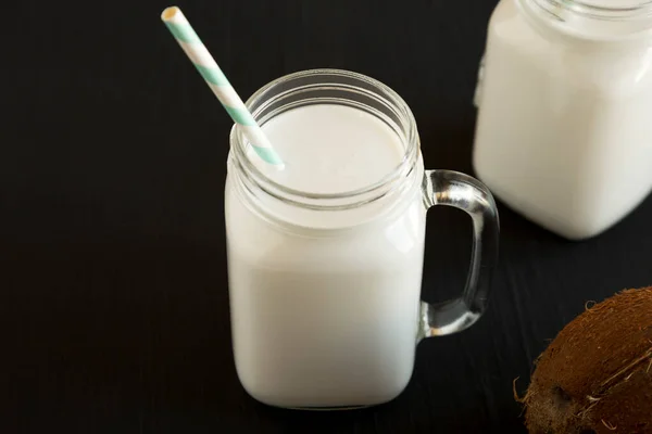 Glazen Potten Gevuld Met Kokosmelk Een Zwart Oppervlak Zijaanzicht Kopieerruimte — Stockfoto