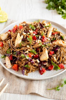 Ev yapımı Baharatlı Tavuk Soba Erişteli Salata Gri bir tabakta Tahta bir yüzey, yan manzara. 