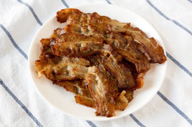 Beyaz tabakta ev yapımı domuz pastırması, düşük açılı. Yakın plan..