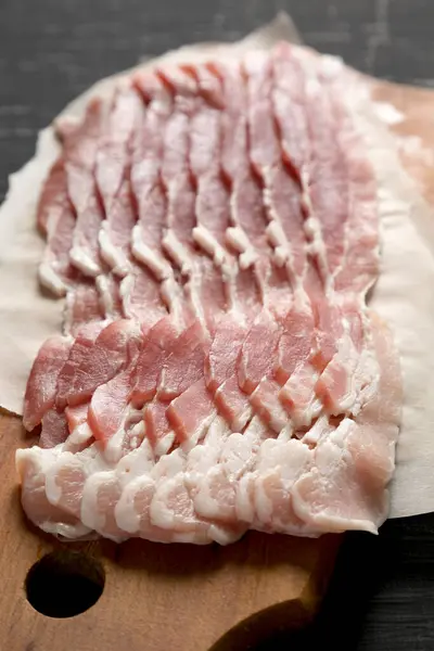 배경에 각도에서 Raw Bacon 클로즈업 — 스톡 사진