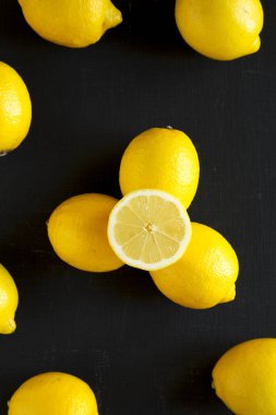 Siyah bir yüzey üzerinde olgun sarı organik limonlar, üst manzara. Dümdüz, tepeden, yukarıdan. 