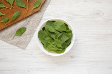 Beyaz kasede taze ıspanak, üst manzara. Yukarıdan, dümdüz yatıyordu. Boşluğu kopyala.