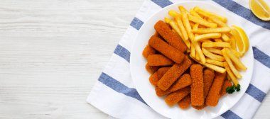 Beyaz ahşap arka planda ev yapımı balık kroket ve patates kızartması. Dümdüz, tepeden, yukarıdan. Metin için boşluk.